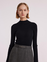 a lady in a black wool seamless sweater